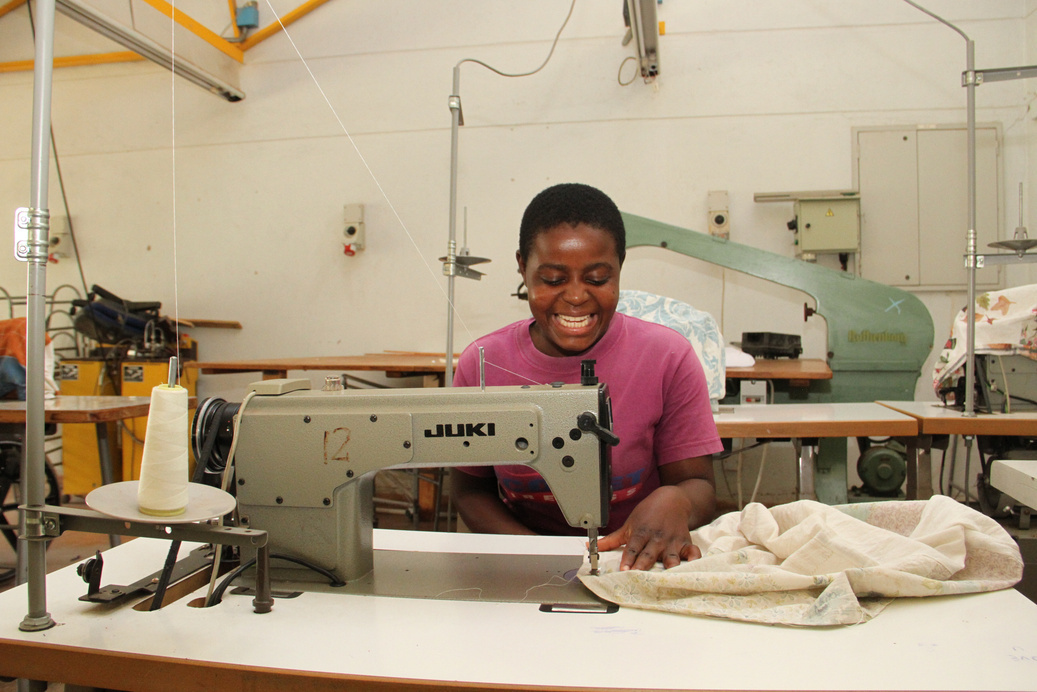 A woman working at a sewing machine in a clothing workshop